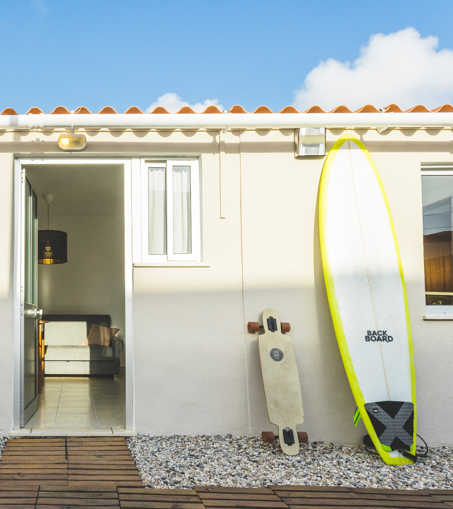 Surfbrett und Surfskate an Hauswand